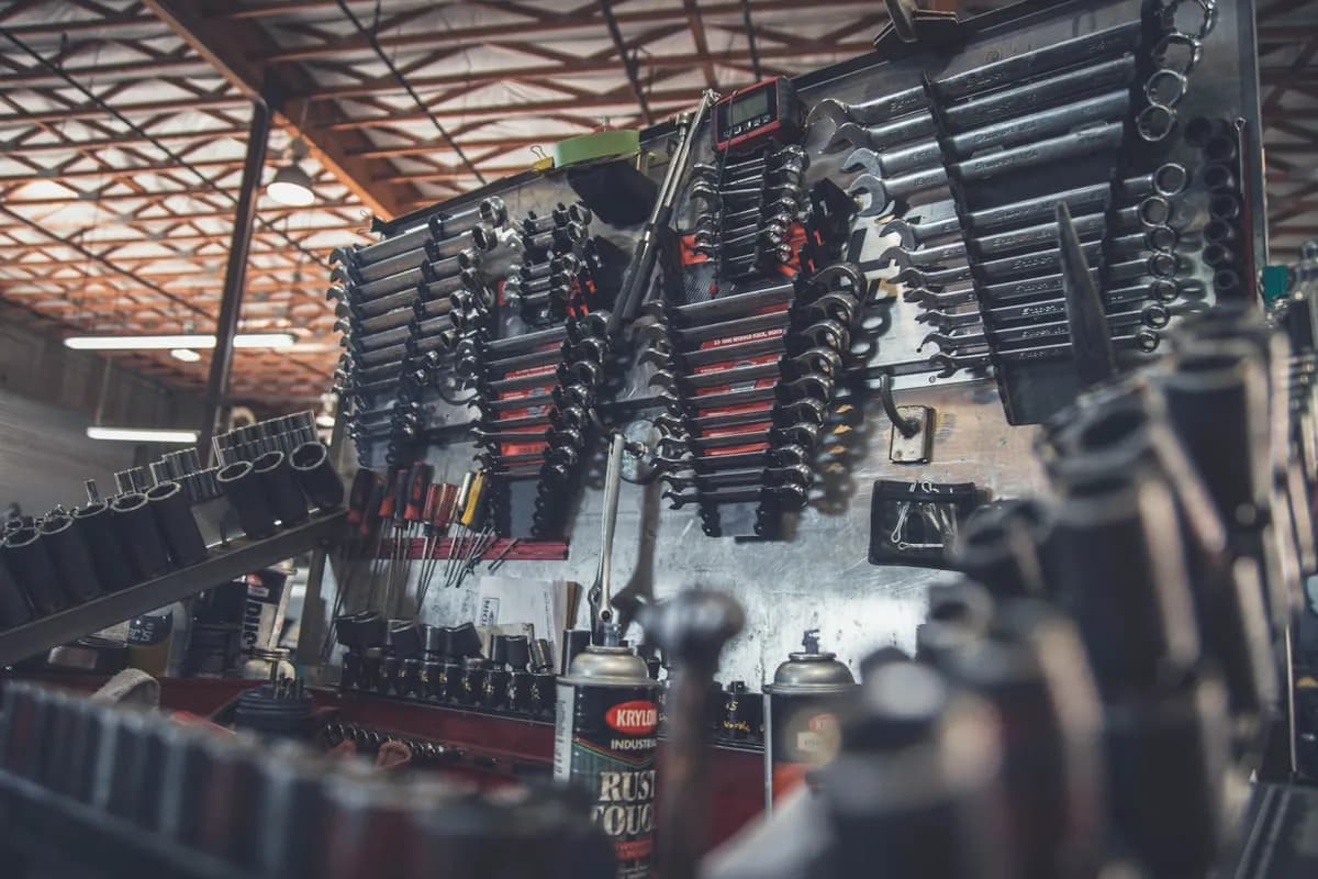 Person inspecting a used car engine bay before purchase
